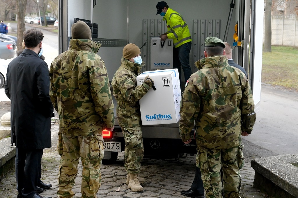 Kipakolják a koronavírus elleni oltóanyagot, a Pfizer-BioNTech vakcinát egy kisteherautóból a Dél-pesti Centrumkórházban 2020. december 26-án. A belgiumi Puursban gyártott, Európában elsõként engedélyeztetett oltóanyagot a kórházból továbbítják a többi a hazai oltópontra. Az elsõ szállítmány 9750 adag oltóanyagot tartalmaz, amely 4875 egészségügyi dolgozó oltását teszi lehetõvé / Fotó: Koszticsák Szilárd / MTI