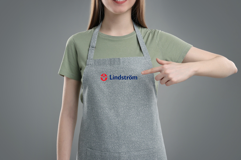 Woman,Pointing,At,Kitchen,Apron,On,Grey,Background,,Closeup.,Mockup