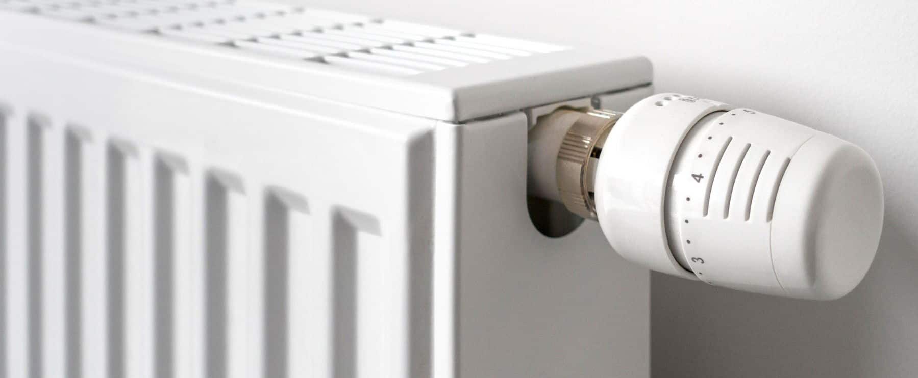 Close-up of thermostatic radiator valve / TVR fitted to household hot water heating system radiator to control the temperature of a room